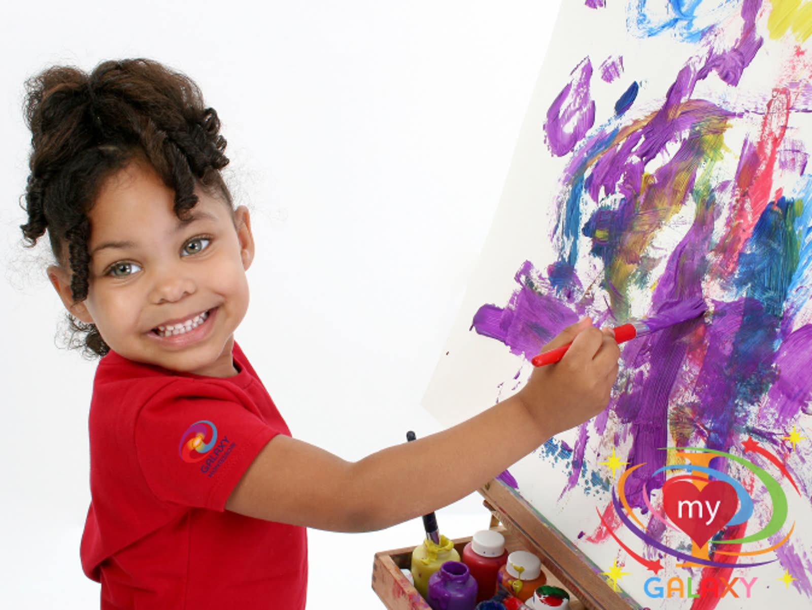 A Galaxy Montessori student painting at an easel